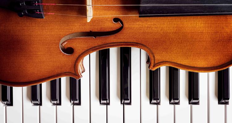 Violin resting on piano keys